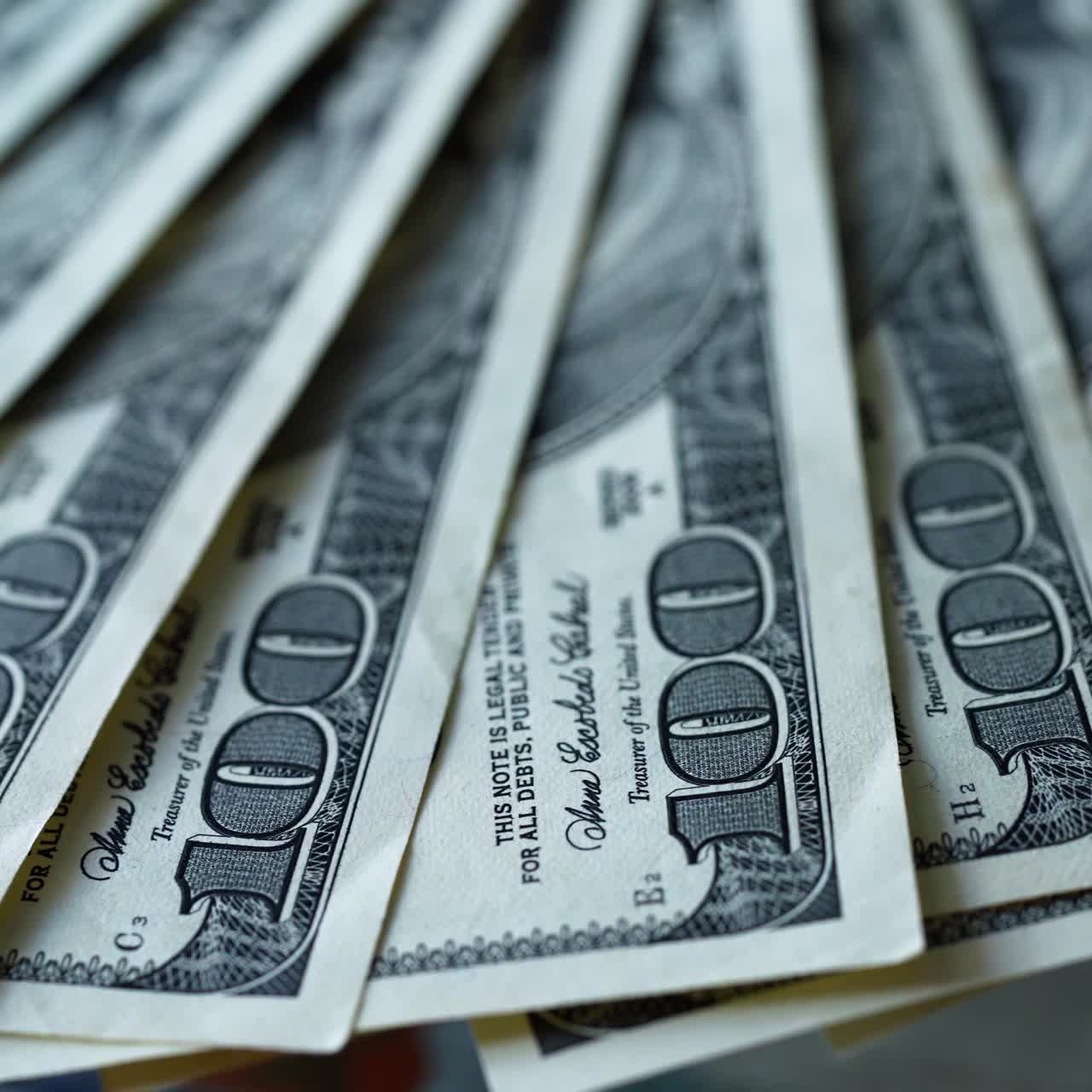 Rich background of one hundred dollars. American money rotating slowly. A lot of paper banknotes of dollar bills spinning. Close-up.