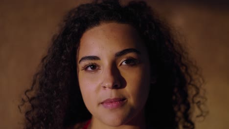 close-up portrait of a young woman with curly hair showing different expressions