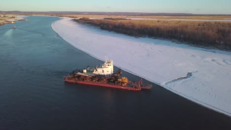 tugboat and barge on a frozen river