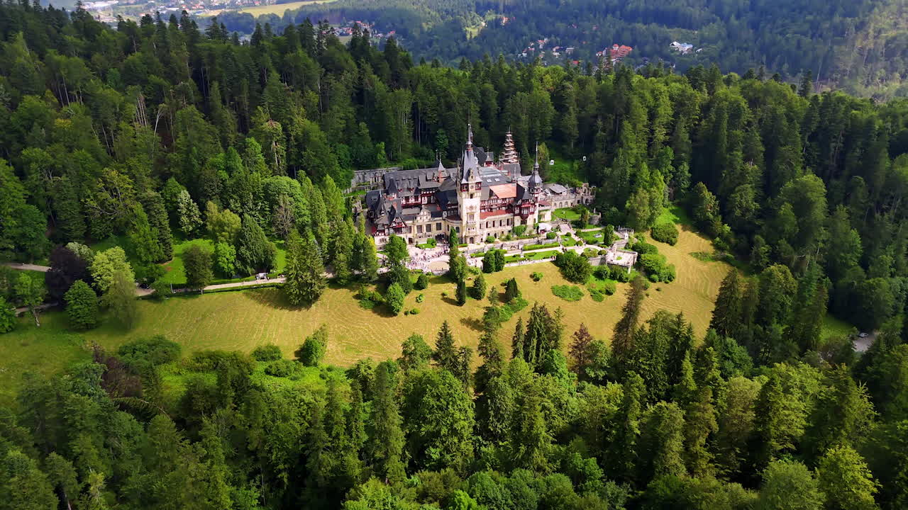 Flight around the famous Peles Castle, Prahova County, Romania in the lush woods. Drone footage over the Carpathian Mountains
