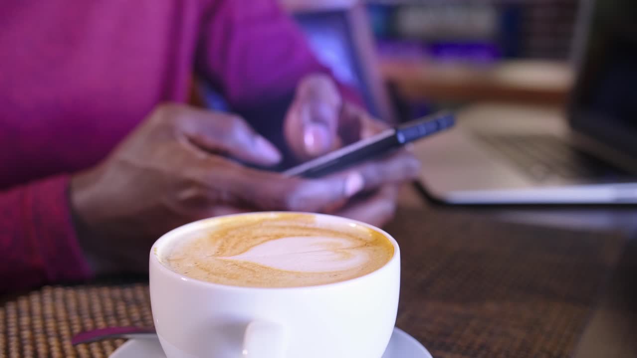 Woman working from a cafe with a latte