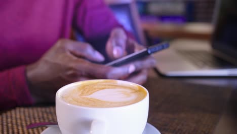 woman working from a cafe with a latte