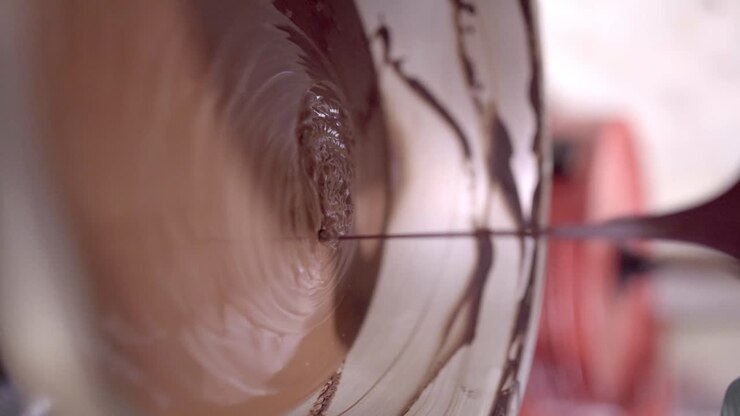 Melted liquid chocolate pouring into bowl