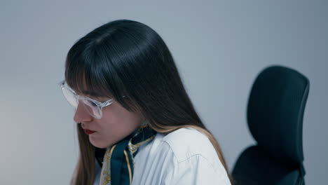 Beautiful-young-woman-with-long-dark-hair-wearing-glasses-answering-a-phone-with-a-client-close-up-in-slow-motion