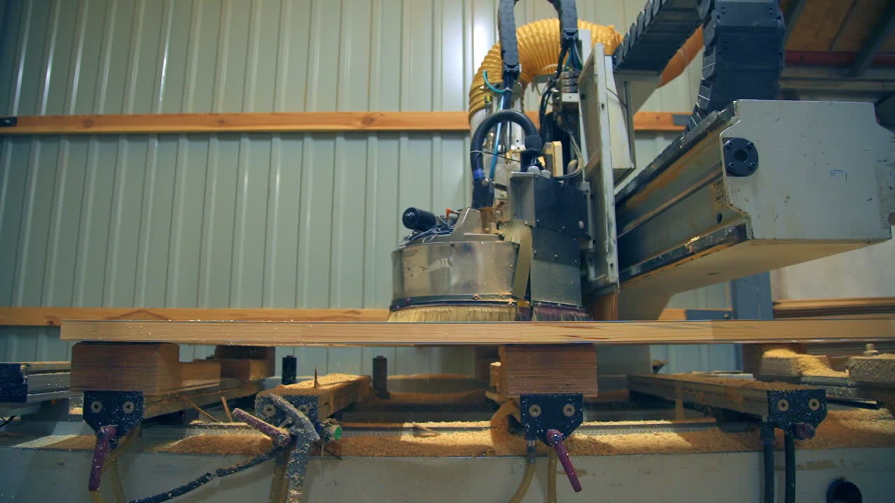 Machine-tool moving along the wooden billet. Timber is being processed in order to make modern doors.