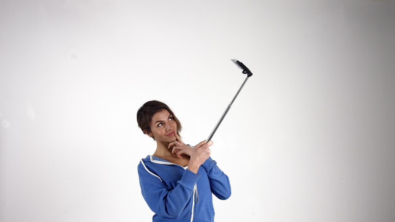 una chica bonita tomando una selfie con un palo