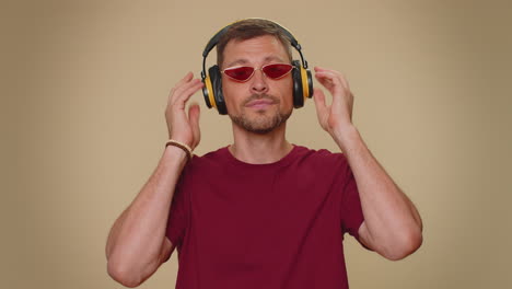 happy handsome relaxed man listening music on headphones and dancing disco fooling around having fun