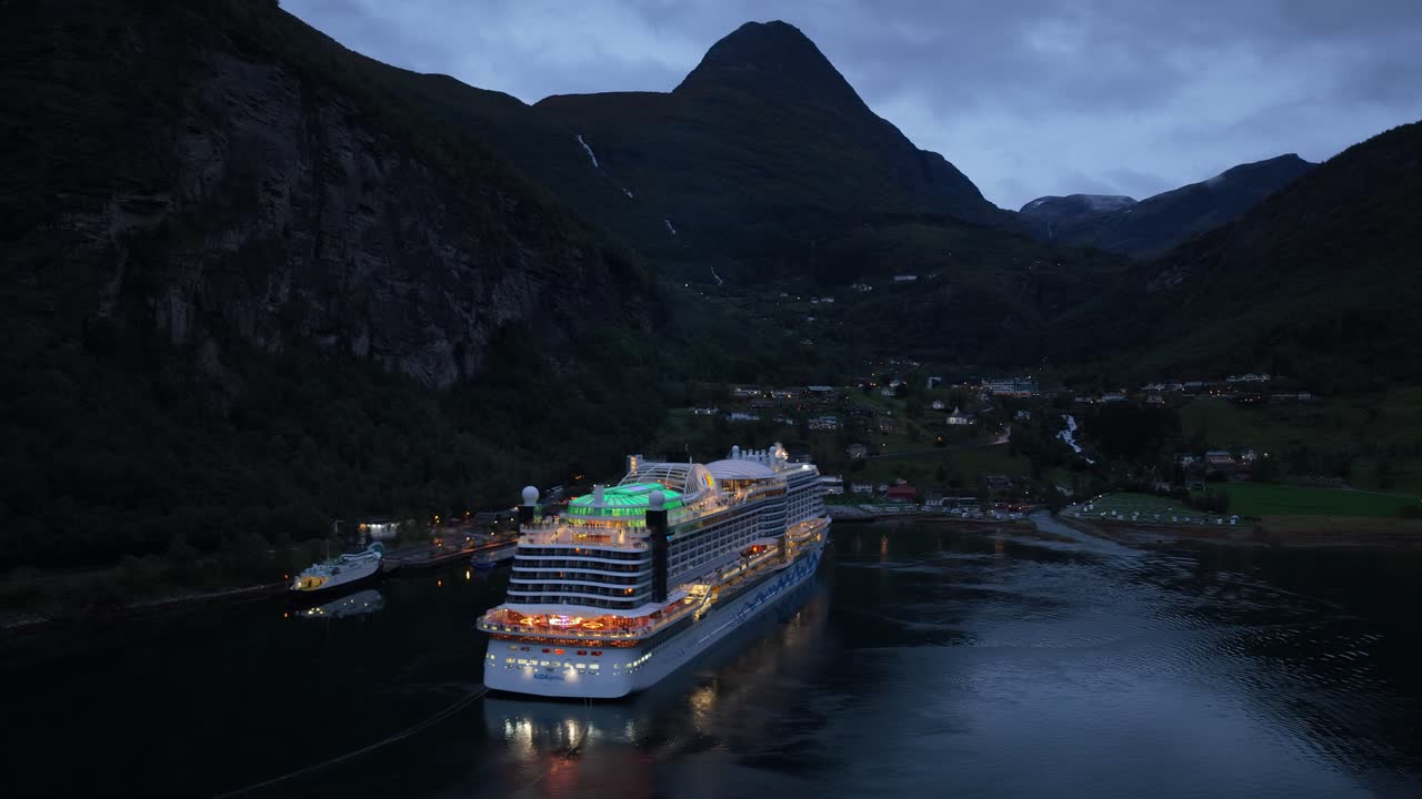 Mattina nuvolosa su Geiranger mentre una nave da crociera entra nel fiordo, vista aerea.