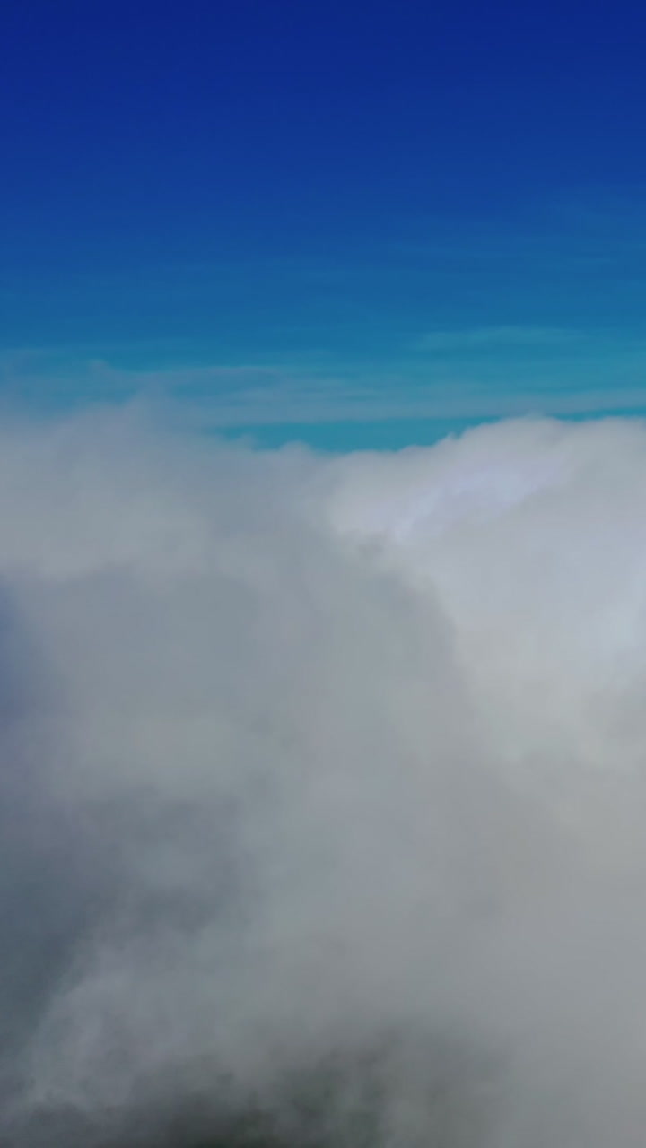 Scenic view of beautiful sky. Flying among soft white clouds moving on blue sky. High in blue sky through the fluffy clouds. Vertical video