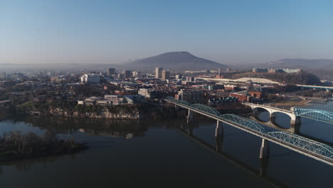 Amplias-Imágenes-Aéreas-Volando-Sobre-El-Río-Tennessee-Hacia-El-Centro-De-Chattanooga-Con-La-Montaña-Mirador-Al-Fondo