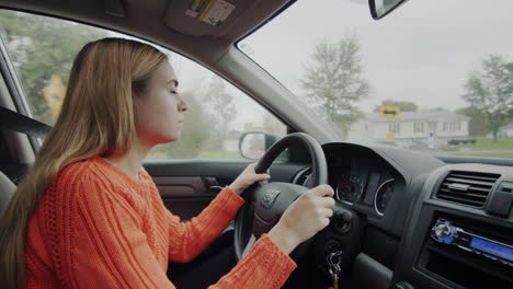 a young woman drives a car through a typical american suburb