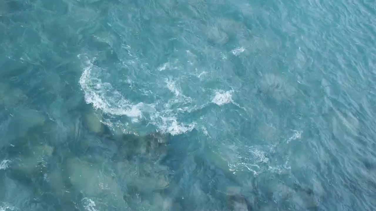 冷たい水が岩の上を勢いよく流れる。上からのショット。