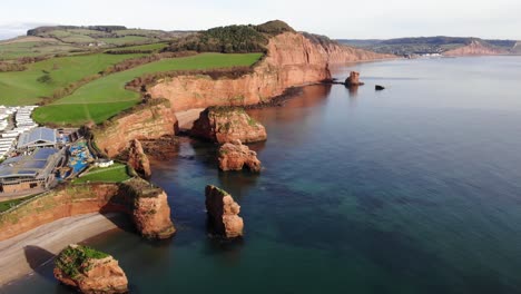 grandiose and panoramic establishing shot of the beautiful and pristine waters at the cost line at ladram bay