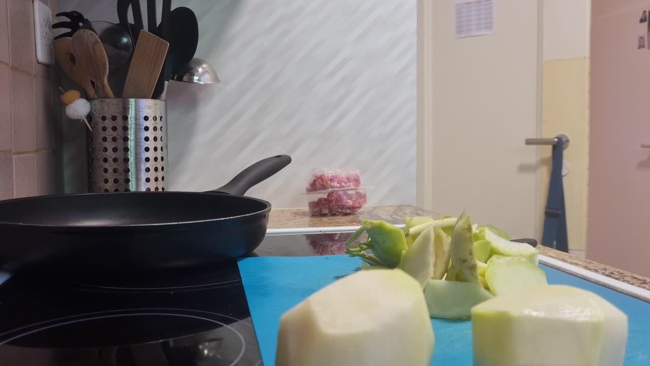 Close-up of woman finishing peeling kohlrabi (cabbage turnip) in her home kitchen, preparing a healthy vegan or vegetarian meal for her family in Switzerland, Europe