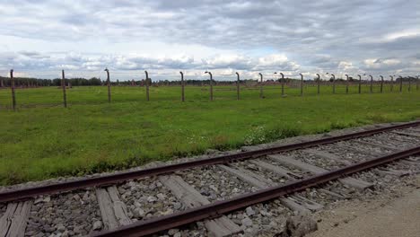 abandoned railroad and barbed-wire fence in auschwitz death