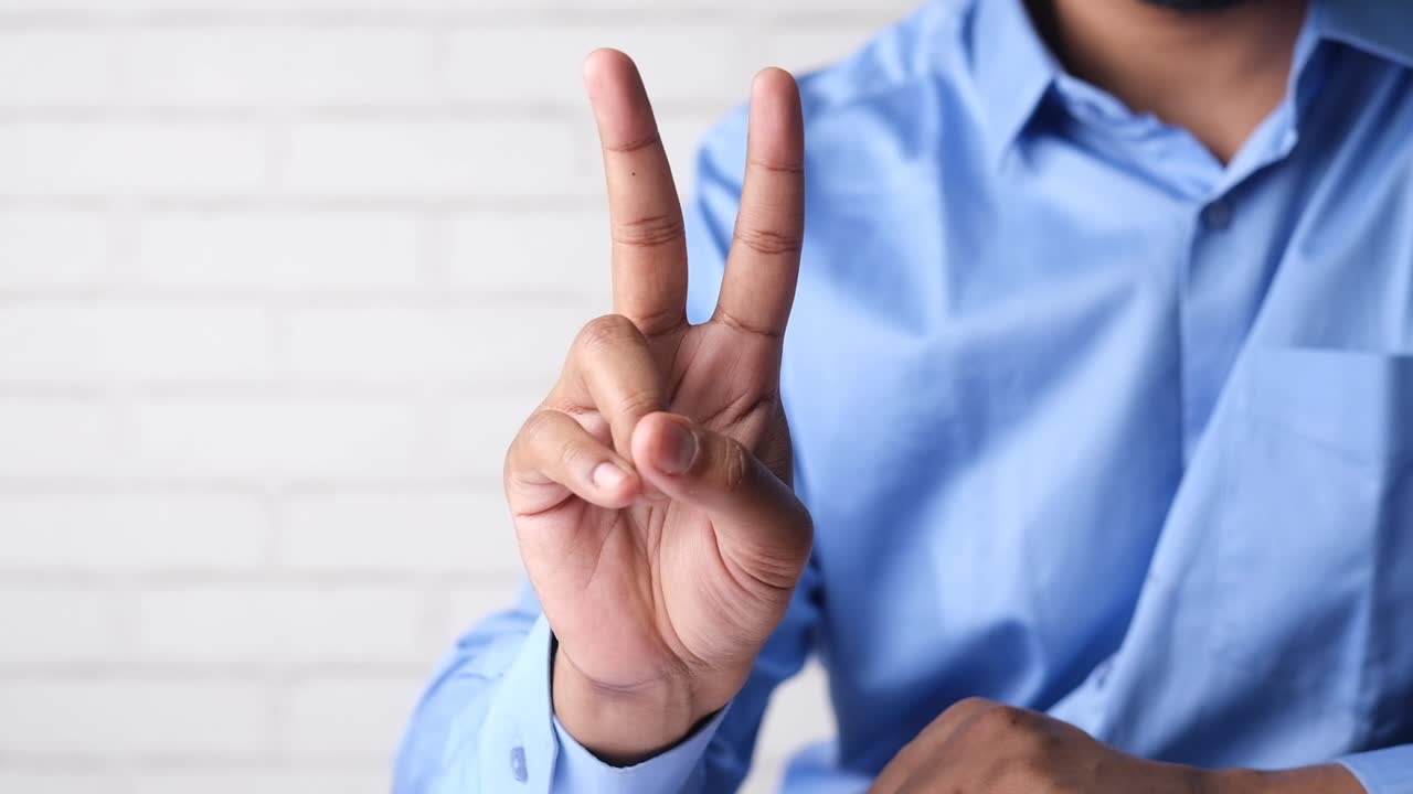 평화 의 표시 를 하는 사람