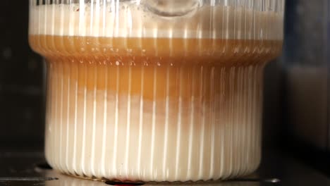 layered coffee drink in a glass container