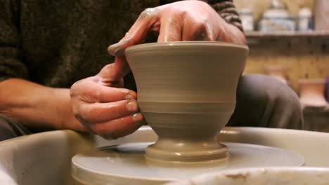 mid section of potter making pot