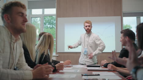 young and charismatic male business coach is speaking in conference for entrepreneurs