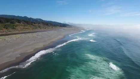 aerial: drone shot descending towards the oregon coastline as the waves roll in