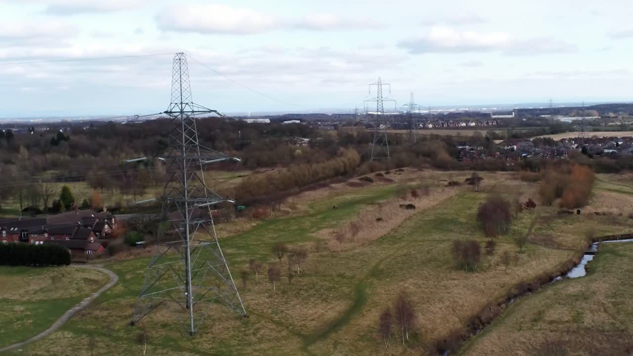 pilón de distribución de electricidad con vistas a la campiña británica, vista aérea que se eleva hacia adelante