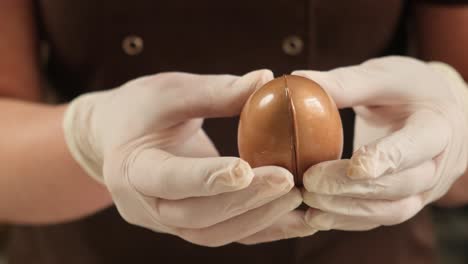 hands in gloves preparing chocolate easter eggs