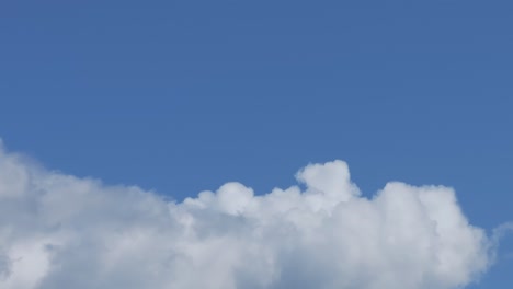 filming-with-a-drone-of-a-cloud-in-166mm,-appreciating-its-details-with-a-turn-of-the-camera-we-see-how-white-it-becomes-and-the-variety-of-blue-tones-that-it-can-take,-its-pompom-shapes-appear