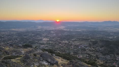 Bright-yellow-sun-on-horizon-during-sunrise-from-Monsanto-Castle,-Portugal