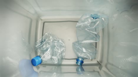 close up video of plastic bottles falling into the garbage bin