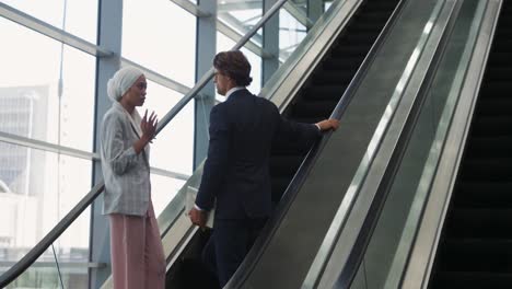 young business people on an escalator in a modern building