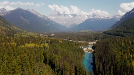 Schwenken-Sie-Nach-Rechts-Und-Fahren-Sie-Mit-Dem-Dolly-Nach-Vorne.-Zoomen-Sie-Auf-Den-Fraser-River-Im-Mount-Robson-Provincial-Park-In-British-Columbia-In-Kanada-An-Einem-Tag-Mit-Sonne-Und-Wolken,-Umgeben-Von-Wald-Und-Schnee-Auf-Den-Berggipfeln