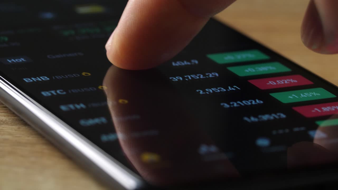 Person using a mobile phone to view cryptocurrency prices