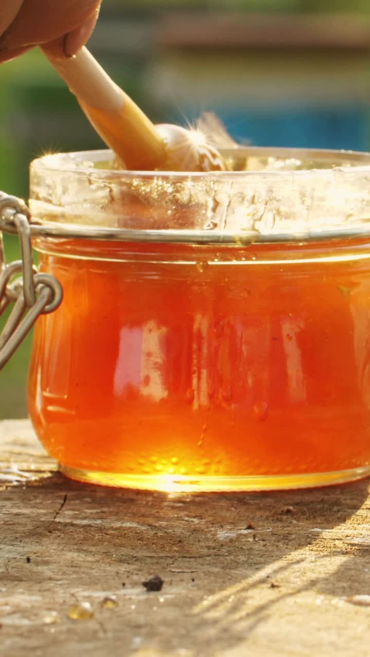 Miele che gocciola dal vaso nel barattolo