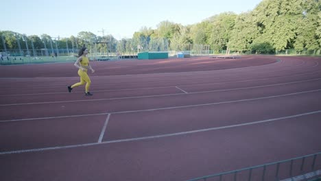 woman jogging on outdoor track in sportswear at athletic field