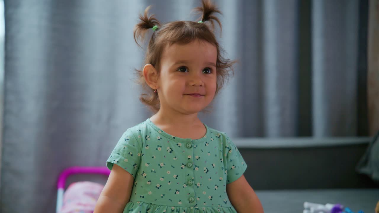 A Delightful Little Girl with Playful Pigtails Enjoys Her Time in a Playful Environment, Showcasing Joy and Innocence in Every Glimpse of Her Smile