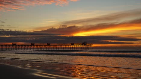 time lapse video of golden sunrise looking onto a pier