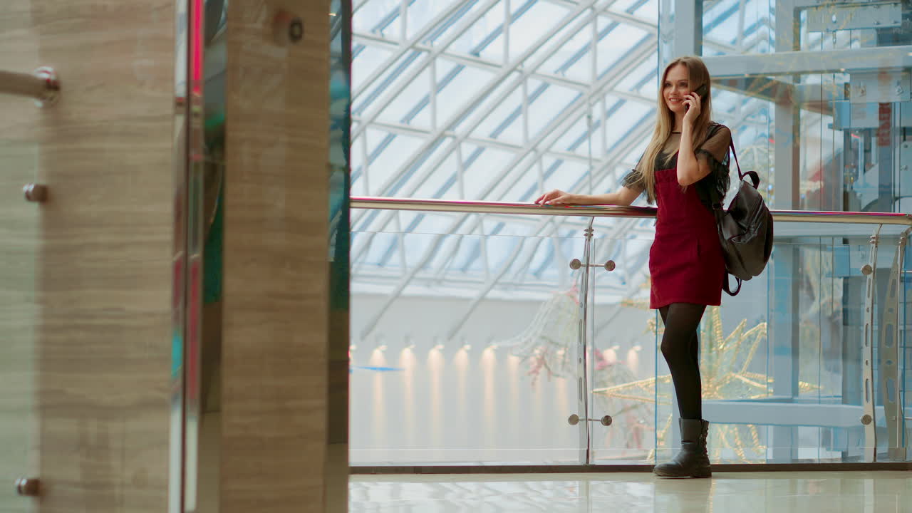 판매, 소비주의: 쇼핑 센터 근처에 서서 이야기하는 스마트폰과 쇼핑 가방을 들고 있는 젊은 여성
