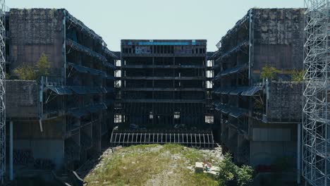inner courtyard of derelict hospital framed by exposed floors and graffiti