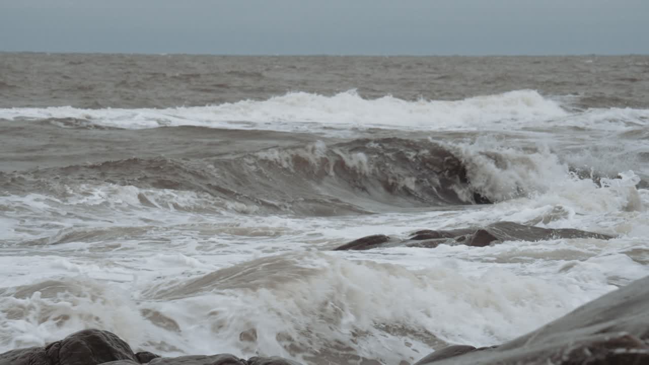 Slow motion waves curl in off the unfriendly seas of Canada's Hudson Bay and crash against the rocky shore