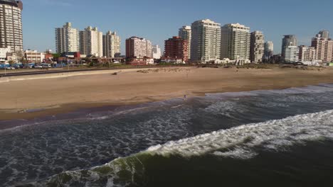 A-drone-rotates-above-a-tourist-on-the-beach-of-Uruguay