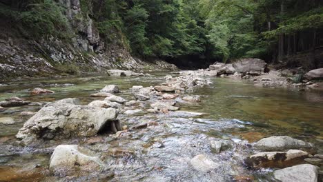 Ein-Blick-Auf-Eine-Japanische-Zen-Flusslandschaft,-Wasser-Fließt-Durch-Waldsteine-Um-Mineralien-Wie-Eisen-Herum,-Die-Für-Sento--Und-Onzen-Bäder-Verwendet-Werden