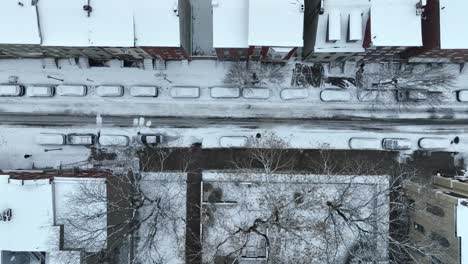 coches cubiertos de nieve, casas y edificios en la calle americana de la ciudad en ee.uu.