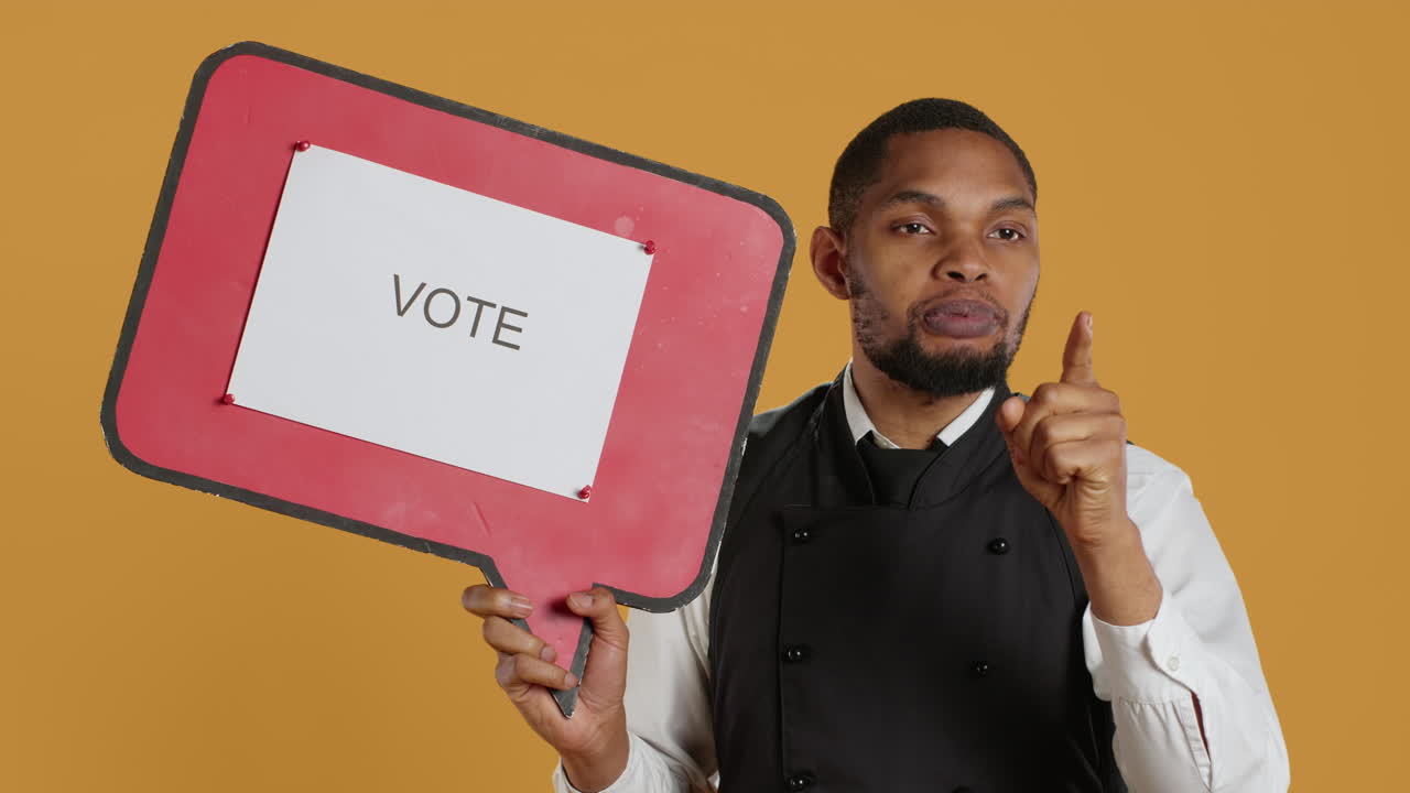 Catering employee showing a message to vote on red speech bubble
