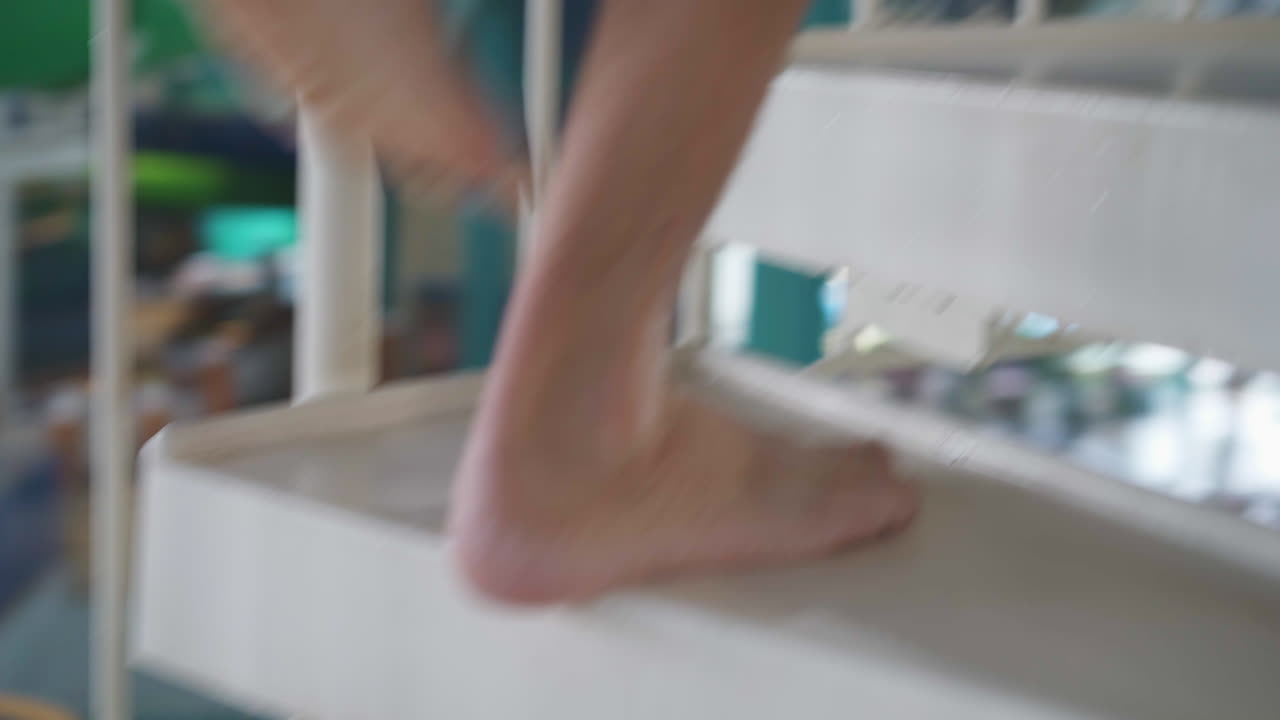 hombre caminando arriba a un tobogán de agua en una piscina cubierta