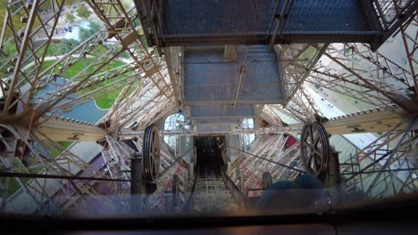 mirando hacia abajo desde el ascensor bajando por la pista dentro de la torre eiffel en parís, francia