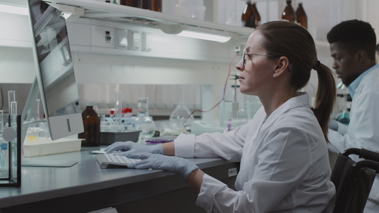Female Scientist in Wheelchair Using Computer in Lab