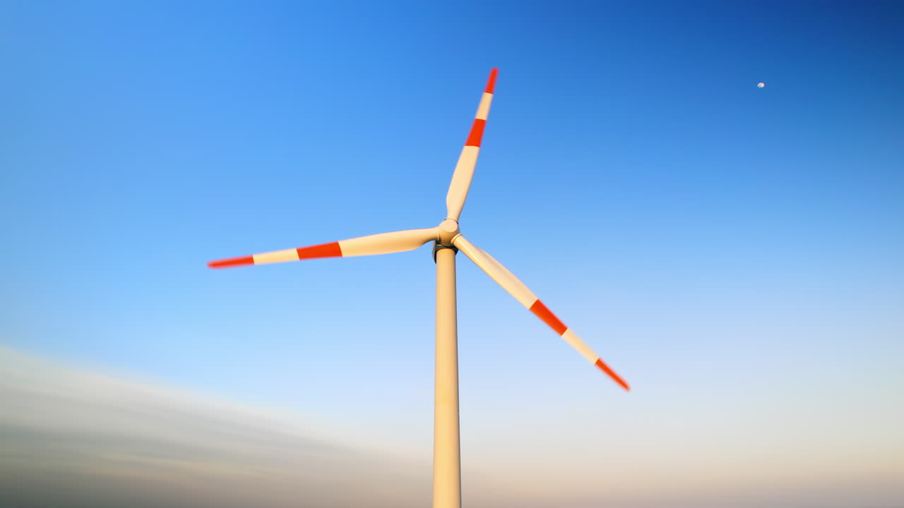 Aerial drone view of a working wind turbine. Sky on the background