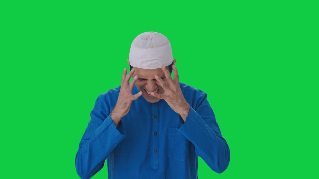 Uomo musulmano frustrato che grida contro qualcuno, con schermo verde.