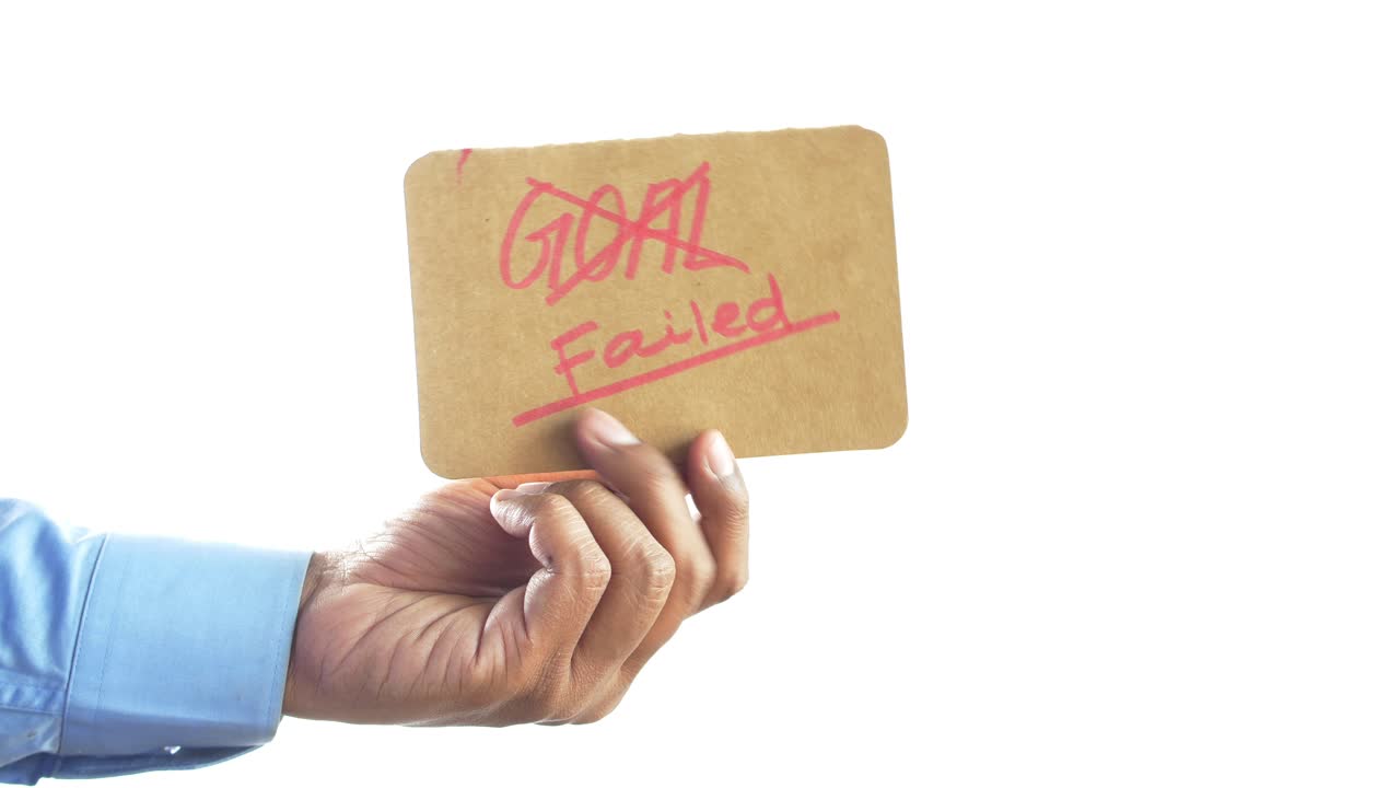 '목표 실패'라고 쓰여진 카드보드 표지판을 들고 있는 손