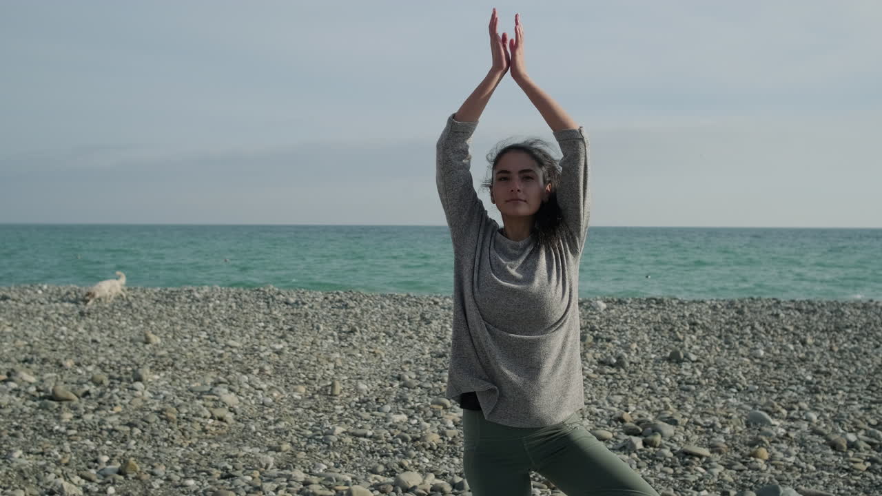 mujer practicando yoga en la playa